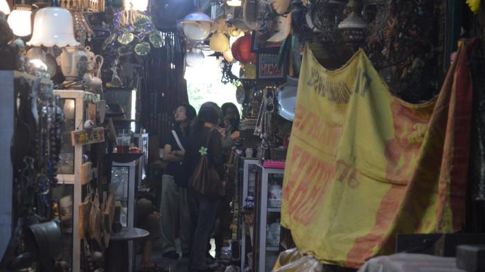 Wisatawan mengunjungi kios dan melihat barang-barang antik yang dijual di Pasar Triwindu Solo, Selasa (15/7/2025). (Foto: Mg/Rohmah Tri Nosita).