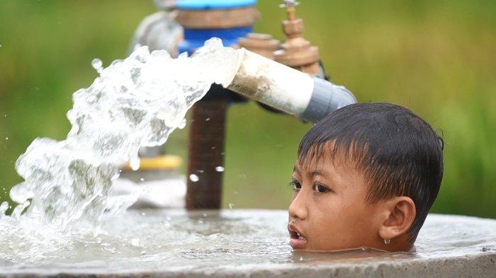 AIR BERSIH - Seorang anak warga Desa Bandungrejo menikmati air bersih Program TMMD 123 Kodim 0716/Demak