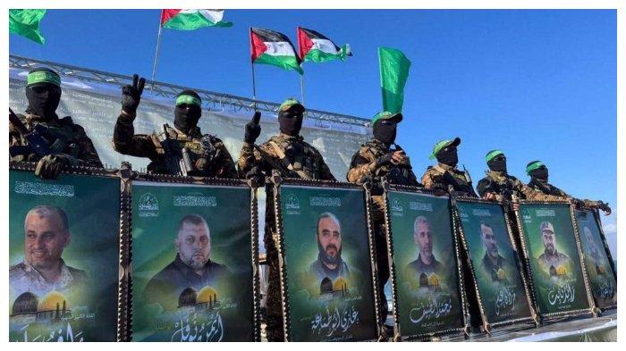 PANGLIMA HAMAS GUGUR – Foto yang diambil dari Press TV tanggal 1 Februari 2025 memperlihatkan anggota Brigade Al Qassam berdiri di atas panggung sambil membawa foto para panglima Hamas yang gugur. Wakil Kepala Politbiro Hamas Khalil Al Hayya mengklaim pembebasan seluruh tanah Palestina dari Israel kini sudah dekat.