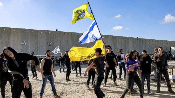Orang-orang menari ketika pengunjuk rasa sayap kanan Israel berkumpul untuk memblokir masuknya truk bantuan kemanusiaan ke Jalur Gaza, di sisi Israel dari perbatasan Karem Shalom pada 6 Februari 2024.