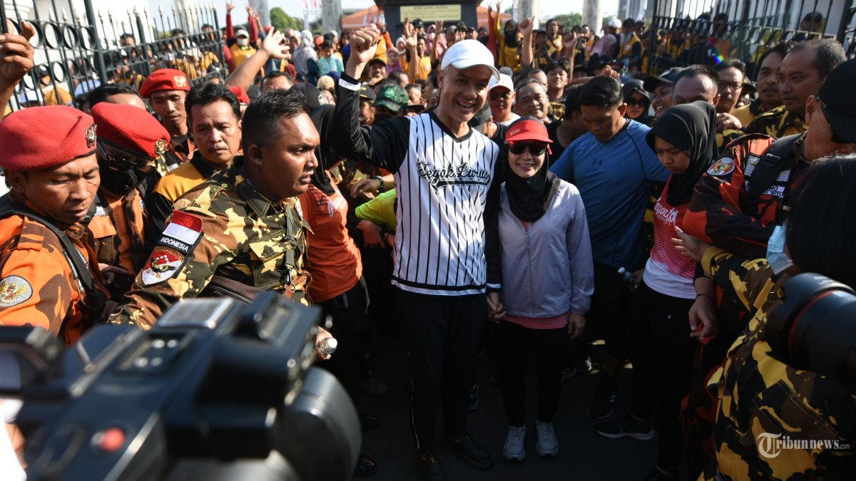BAHAS PEREMPUAN - Bakal Calon Presiden Ganjar Pranowo (kaos putih garis hitam) didampingi istri dan Ketua Umum DPP Partai Hanura Dr. (HC) Oesman Sapta mengibarkan bendera start 'Jalan Sehat Bersama Hanura