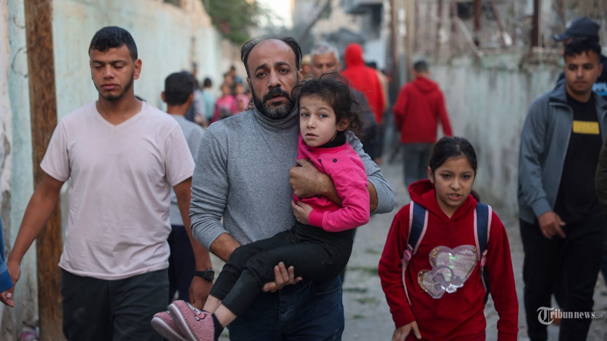 Orang-orang melarikan diri menyusul serangan Israel di Rafah di Jalur Gaza selatan pada 23 November 2023, di tengah pertempuran yang sedang berlangsung antara Israel dan kelompok militan Palestina Hamas. (Photo by MOHAMMED ABED / AFP)