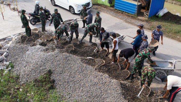 GOTONG ROYONG - Anggota Satgas Kodim 0716/Demak bergotong royong mengangkat bahan material Desa Bandungrejo.