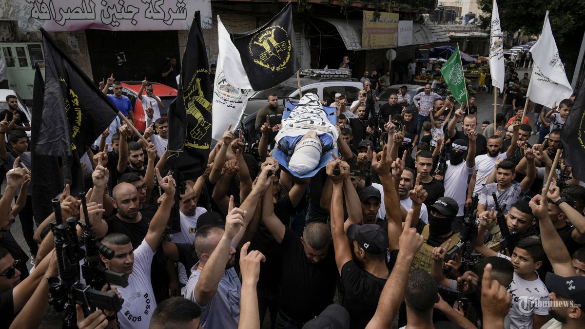Warga Palestina membawa jenazah Ahmad Awawda, 19, yang tewas dalam bentrokan dengan pasukan Israel di dekat kota Nablus sehari sebelumnya, saat pemakamannya di kota Jenin, Tepi Barat, Minggu, 8 Oktober 2023. Awawda adalah seorang anggota kelompok bersenjata Batalyon Jenin, sebagian besar terdiri dari orang-orang yang sangat muda. Dia terbunuh dalam baku tembak. (AP Photo/Majdi Mohammed)