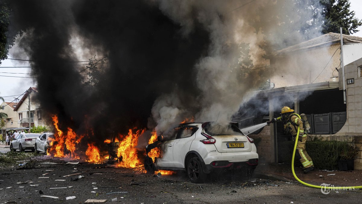 Petugas pemadam kebakaran Israel memadamkan api di lokasi yang terkena roket yang ditembakkan dari Jalur Gaza, di Ashkelon, Israel selatan, Senin, 9 Oktober 2023. (AP Photo/Tsafrir Abayov)