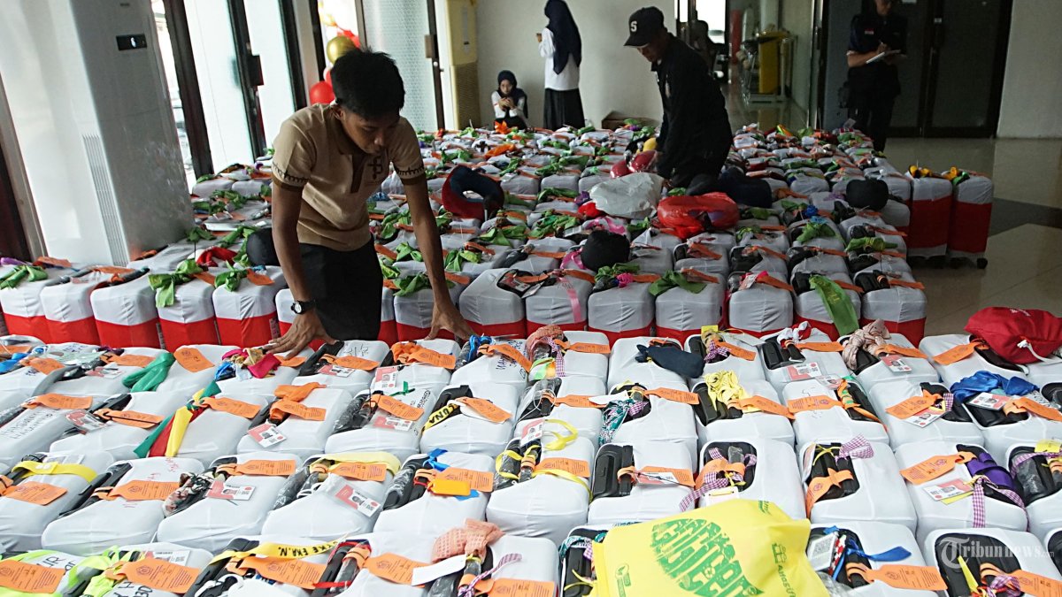 Petugas merapikan koper jamaah calon haji di Asrama Haji Pondok Gede, Jakarta Timur, Sabtu (11/5/2024). Sebanyak 385 calon haji asal DKI Jakarta yang tergabung dalam kloter pertama embarkasi haji Jakarta-Pondok Gede tiba di Asrama Haji untuk melakukan pendataan, cek kesehatan serta pengambilan passport dan pemasangan gelang sebagai tanda jamaah haji asal Indonesia sebelum diberangkatkan menuju tanah suci. Tribunnews/Jeprima 
