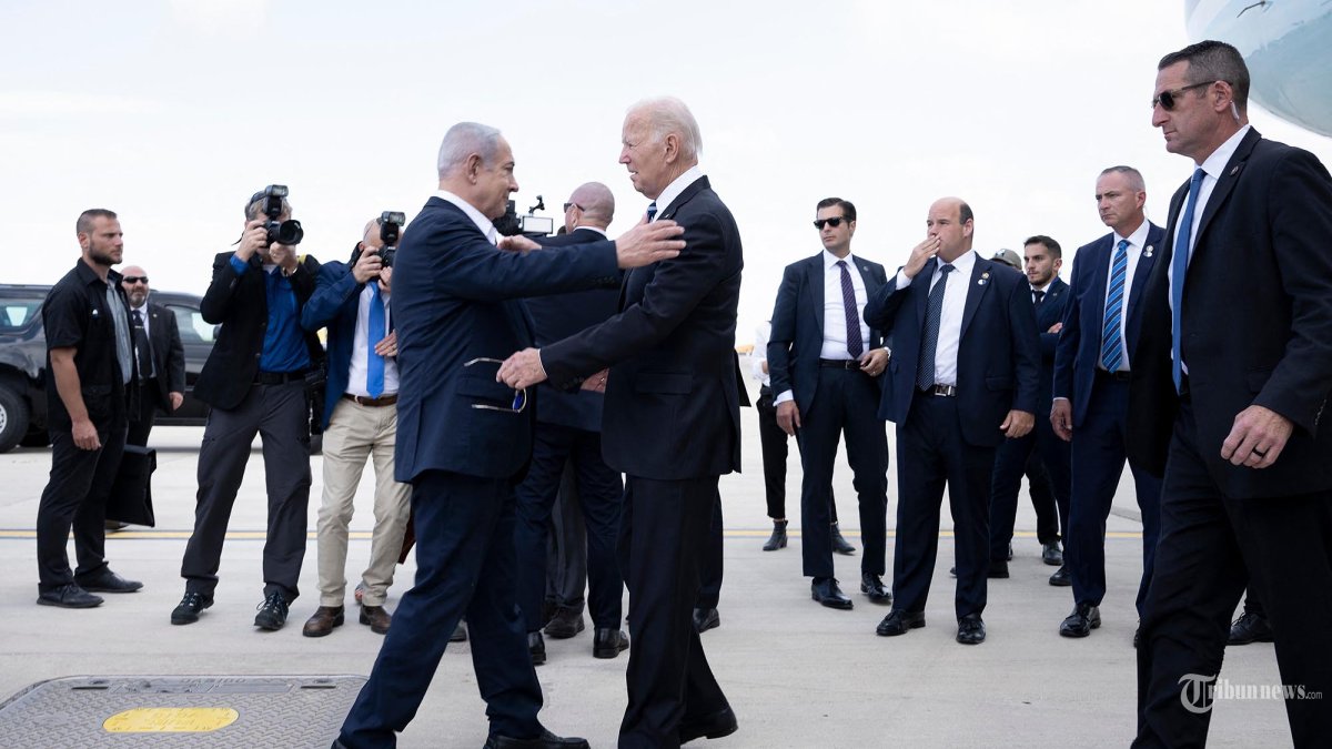 Perdana Menteri Israel Benjamin Netanyahu (kiri) menyambut Presiden AS Joe Biden setibanya di bandara Ben Gurion Tel Aviv pada 18 Oktober 2023, di tengah pertempuran yang sedang berlangsung antara Israel dan kelompok Palestina Hamas. Biden mendarat di Israel pada 18 Oktober, dalam kunjungan solidaritas menyusul serangan Hamas yang memicu pembalasan besar-besaran Israel. (Brendan Smialowski / AFP)