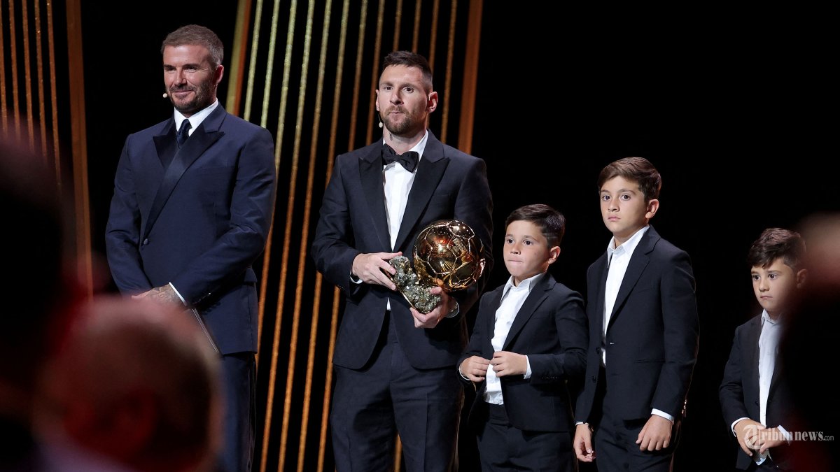 Penyerang Inter Miami CF asal Argentina Lionel Messi (tengah) bereaksi dengan trofinya di samping anak-anaknya di atas panggung saat ia menerima penghargaan Ballon d'Or ke-8 di samping Mantan pemain sepak bola Inggris dan salah satu pemilik Inter Miami David Beckham (Kiri) selama tahun 2023 Upacara penghargaan Ballon d'Or France Football di Theatre du Chatelet di Paris pada 30 Oktober 2023. (Photo by FRANCK FIFE / AFP)
