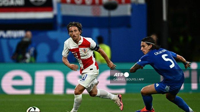 (Dari kiri) Gelandang Kroasia #10 Luka Modric dan bek Italia #05 Riccardo Calafiori berebut bola pada pertandingan sepak bola Grup B UEFA Euro 2024 antara Kroasia dan Italia di Stadion Leipzig di Leipzig pada 24 Juni 2024. (Foto oleh GABRIEL BUYS / AFP)