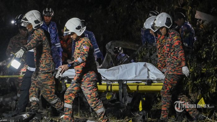 Anggota departemen pemadam kebakaran dan penyelamatan membawa jenazah dari lokasi jatuhnya sebuah pesawat di Shah Alam, negara bagian Selangor Malaysia pada 17 Agustus 2023. Sebuah pesawat ringan menabrak sebuah jalan di negara bagian Selangor tengah Malaysia pada 17 Agustus, menewaskan delapan orang di papan dan dua pengendara di tanah, kata kepala polisi setempat. (Photo by Muhammad Lutfi / AFP)