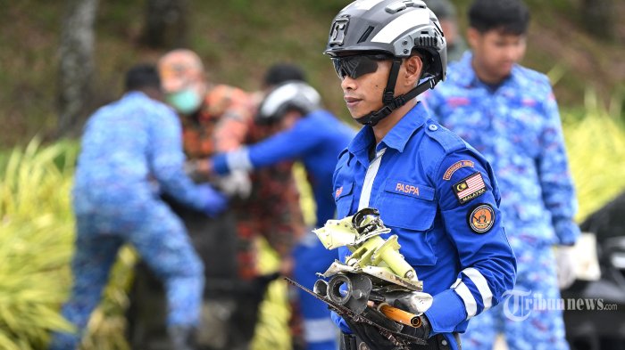 Personil tim Tanggap Darurat dan Bencana Khusus mengumpulkan puing-puing di lokasi kecelakaan di Shah Alam pada 18 Agustus 2023, sehari setelah sebuah pesawat ringan jatuh di negara bagian Selangor tengah Malaysia. Sebuah pesawat ringan menabrak jalan empat jalur di dekat ibu kota Malaysia pada 17 Agustus, menewaskan delapan orang di dalamnya dan dua pengendara di darat, kata kepala polisi setempat. (Photo by MOHD RASFAN / AFP)