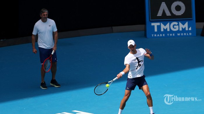 Petenis Serbia Novak Djokovic (kanan) mengambil bagian dalam sesi latihan di Melbourne menjelang turnamen tenis Australia Terbuka pada 11 Januari 2022, sehari setelah pengadilan membatalkan keputusan pemerintah Australia untuk membatalkan visanya dengan alasan vaksinasi Covid-19. (Photo by Kelly Defina / POOL / AFP) 