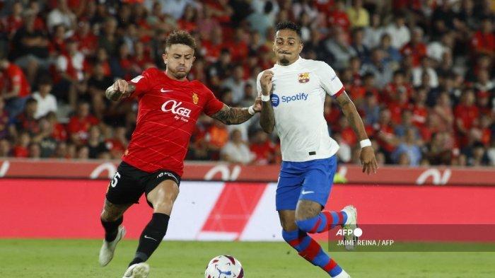 Bek Real Mallorca, Pablo Maffeo (kiri) berebut bola dengan Raphinha selama pertandingan di stadion Mallorca Son Moix pada 26 September 2023.