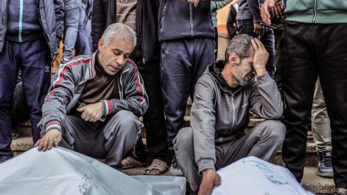 Reaksi para pelayat dengan menyelimuti jenazah kerabatnya yang terbunuh setelah serangan Israel, di rumah sakit Nasser milik Khan Yunis di Jalur Gaza selatan pada 9 Desember 2023, di tengah berlanjutnya pertempuran antara Israel dan kelompok militan Palestina Hamas.