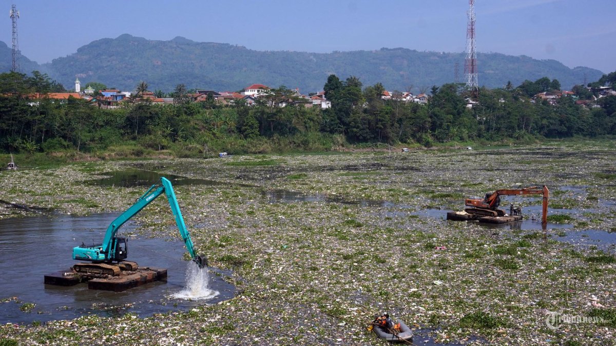 Petugas menggunakan alat berat beko membersihkan sampah yang kembali menghapar di aliran Sungai Citarum, Desa Selacau, Kecamatan Batujajar, Kabupaten Bandung Barat, Jawa Barat, Kamis (20/6/2024). Sekretaris Daerah Provinsi Jawa Barat, Herman Suryatman memastikan proses pembersihan sampah di Sungai Citarum kawasan Jembatan Babakan Sapan (BBS) terus berpogres. Pembersihan ditargetkan rampung akhir Juli 2024 akibat sampah yang terus menumpuk di aliran sungai tersebut. (TRIBUN JABAR/GANI KURNIAWAN) *** Local Caption *** Pembersihan Sampah Sungai Citarum di Jembatan BBS