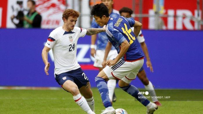 Penyerang Amerika Serikat, Josh Sargent (kiri) dihadang fullback Jepang Takehiro Tomiyasu dalam pertandingan persahabatan di Dusseldorf, Jerman barat, pada 23 September 2022.