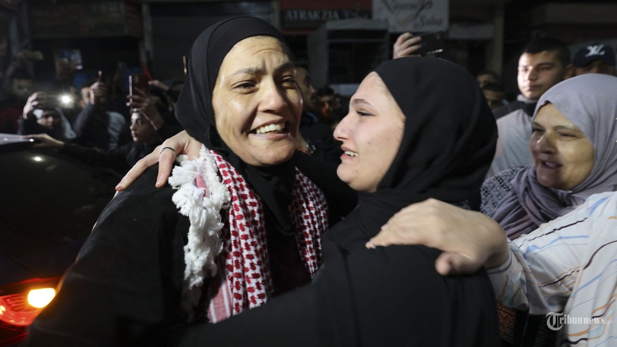 Rawda Abu Ajamieh (Kiri) memeluk seorang kerabat setelah dia dibebaskan dari penjara Israel sebagai bagian dari perjanjian gencatan senjata antara Israel dan Hamas di kamp pengungsi al-Duheishe di Tepi Barat yang diduduki Betlehem, 24 November 2023. Setelah 48 hari baku tembak dan pemboman yang merenggut ribuan nyawa, sandera pertama yang dibebaskan berdasarkan kesepakatan gencatan senjata antara Israel dan Hamas diserahkan pada 24 November, kata kedua belah pihak, hampir tujuh minggu setelah mereka ditangkap. (Photo by HAZEM BADER / AFP)
