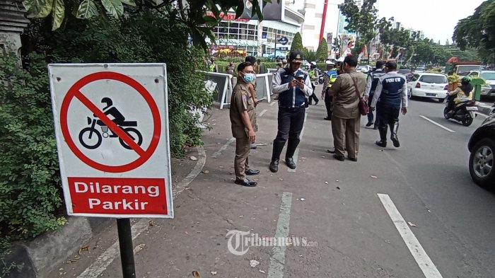 PENERTIBAN PARKIR LIAR - Petugas gabungan dari kepolisian, dishub dan Satpol PP Kota Tangerang, melakukan penertiban parkir liar di Jalan Perintis Kemerdekaan, Kota Tangerang, Senin (22/8/2022). Petugas melakukan penindakan dengan menggemboskan ban kendaraan yang melanggar karena dinilai melanggar ketertiban umum dan kerap menimbulkan kemacetan. WARTA KOTA/NUR ICHSAN