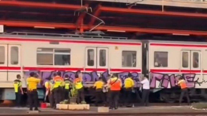 Petugas tengah menghapus grafiti yang menyasar kereta Commuter Line no 5023 jurusan Manggarai-Kampung Bandan, Rabu (5/6/2024).