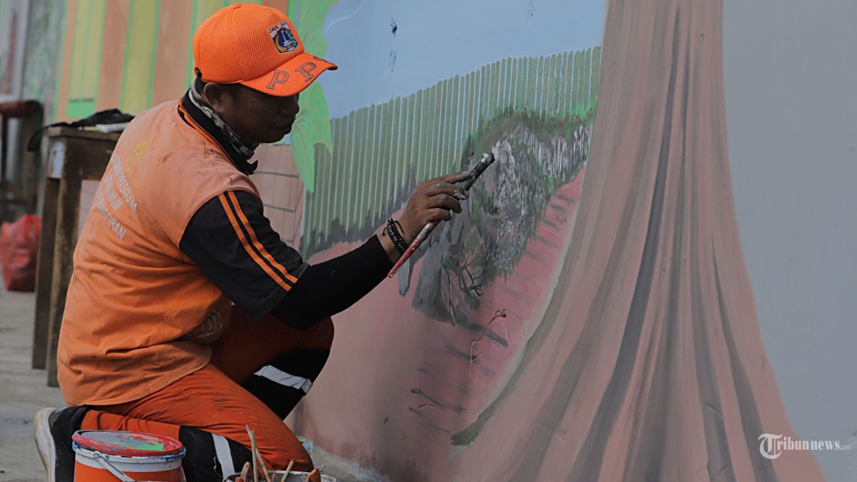 Petugas Penanganan Prasarana dan Sarana Umun (PPSU) membuat mural di kawasan Pancoran, Jakarta selatan, Selasa (5/3/2024). PPSU kelurahan Pancoran menghias tembok dengan mural sebagai peghias taman serta memberi nyaman bagi para pejalan kaki yang akan melintas. Tribunnews/Jeprima 