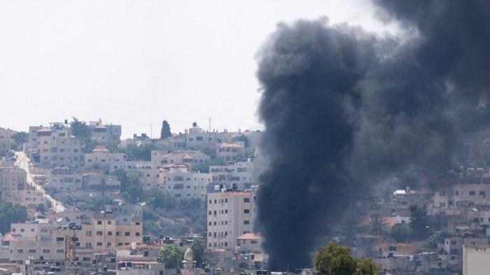 Asap mengepul selama operasi tentara Israel di Jenin di Tepi Barat yang diduduki pada 3 Juli 2023. Israel telah meningkatkan operasi di Tepi Barat utara, rumah bagi kota Jenin dan kamp pengungsi yang berdekatan, kubu kelompok bersenjata Palestina di mana terdapat menjadi serentetan serangan terhadap orang Israel serta serangan oleh pemukim Yahudi terhadap komunitas Palestina.