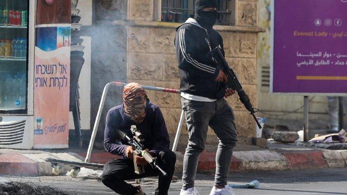 Militan bersenjata Palestina mengambil posisi selama konfrontasi dengan tentara Israel di kota Jenin Tepi Barat yang diduduki pada 3 Juli 2023. Tentara Israel mengatakan telah melancarkan serangan pesawat tak berawak di Jenin sebagai bagian dari 
