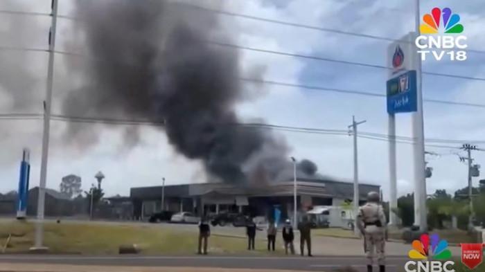 KONFLIK THAILAND-KAMBOJA - Tangkapan layar YouTube CNBC-TV18 pada Sabtu (26/7/2025). bangunan yang terbakar dengan asap hitam tebal membumbung tinggi ke udara. Insiden kebakaran di sebuah lokasi yang dekat dengan stasiun pengisian bahan bakar atau minimarket yang terlihat dari logo PTT dan 7-Eleven Thailand akibat konflik yang memanas dengan Kamboja