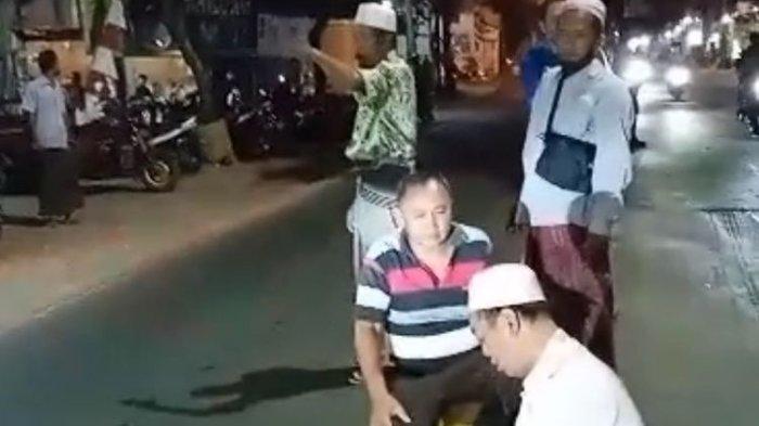 Tangkapan video pria paruh baya menunaikan salat di tengah Jalan Raya Sembayat, Kecamatan Manyar, Gresik, Jawa Timur.