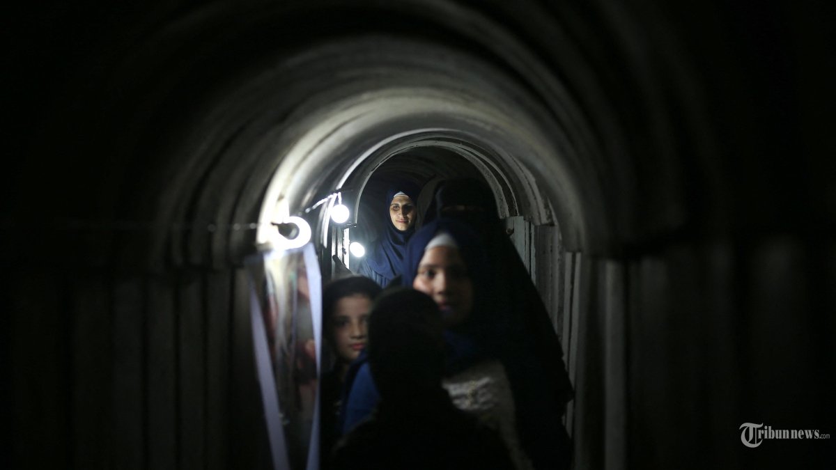 Warga Palestina berjalan di dalam terowongan Hamas yang digunakan militer Hamas di kamp pemuda yang dikelola Hamas, di Kota Gaza.