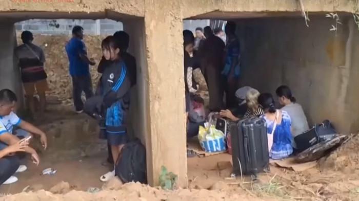 KONFLIK THAILAND KAMBOJA - Sejumlah warga Thailand berlindung di bunker seadanya sesaat militer Kamboja melakukan serangan di perbatasan kedua negara pada Kamis (24/7/2025). 