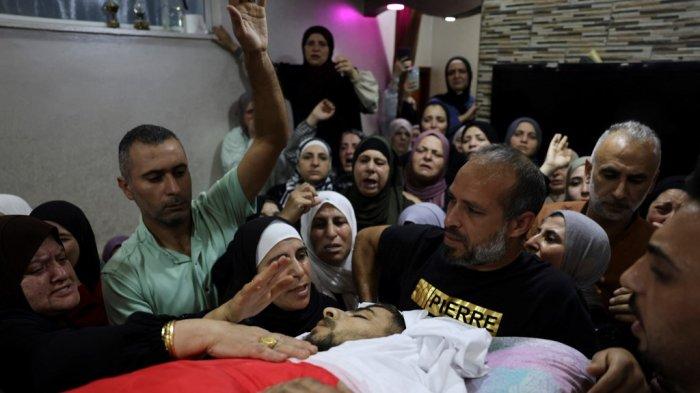 Anggota keluarga Palestina mengucapkan selamat tinggal kepada Mahmud al-Atrash yang berusia 22 tahun, yang dibunuh oleh pasukan keamanan Israel dalam serangan di desa Halhoul, utara kota Hebron di Tepi Barat yang diduduki pada 6 November 2023, di tengah pertempuran yang sedang berlangsung antara Israel dan kelompok Palestina Hamas di Jalur Gaza.