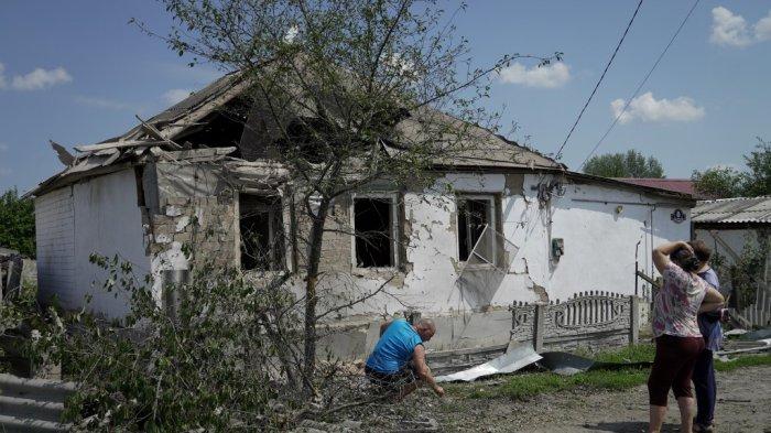Para wanita melihat rumah yang hancur akibat serangan Ukraina baru-baru ini di kota Valuyki, dekat perbatasan dengan Ukraina di wilayah Belgorod, pada 5 Juli 2023.