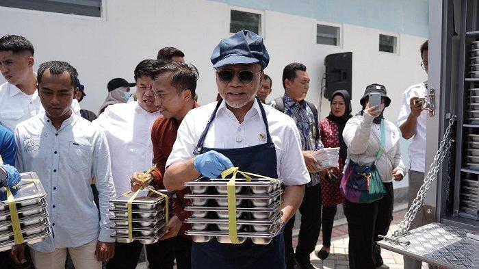 MAKAN BERGIZI GRATIS - Menko Pangan Zulhas saat ikut membantu menyakurkan makan bergizi gratis di SMPN 2 Rogojampi, Banyuwangi, Jawa Timur. Zulhas juga menyerahkan gaji pokoknya kepada dua siswa Sapian dan Nadita, Selasa (4/2/2025).