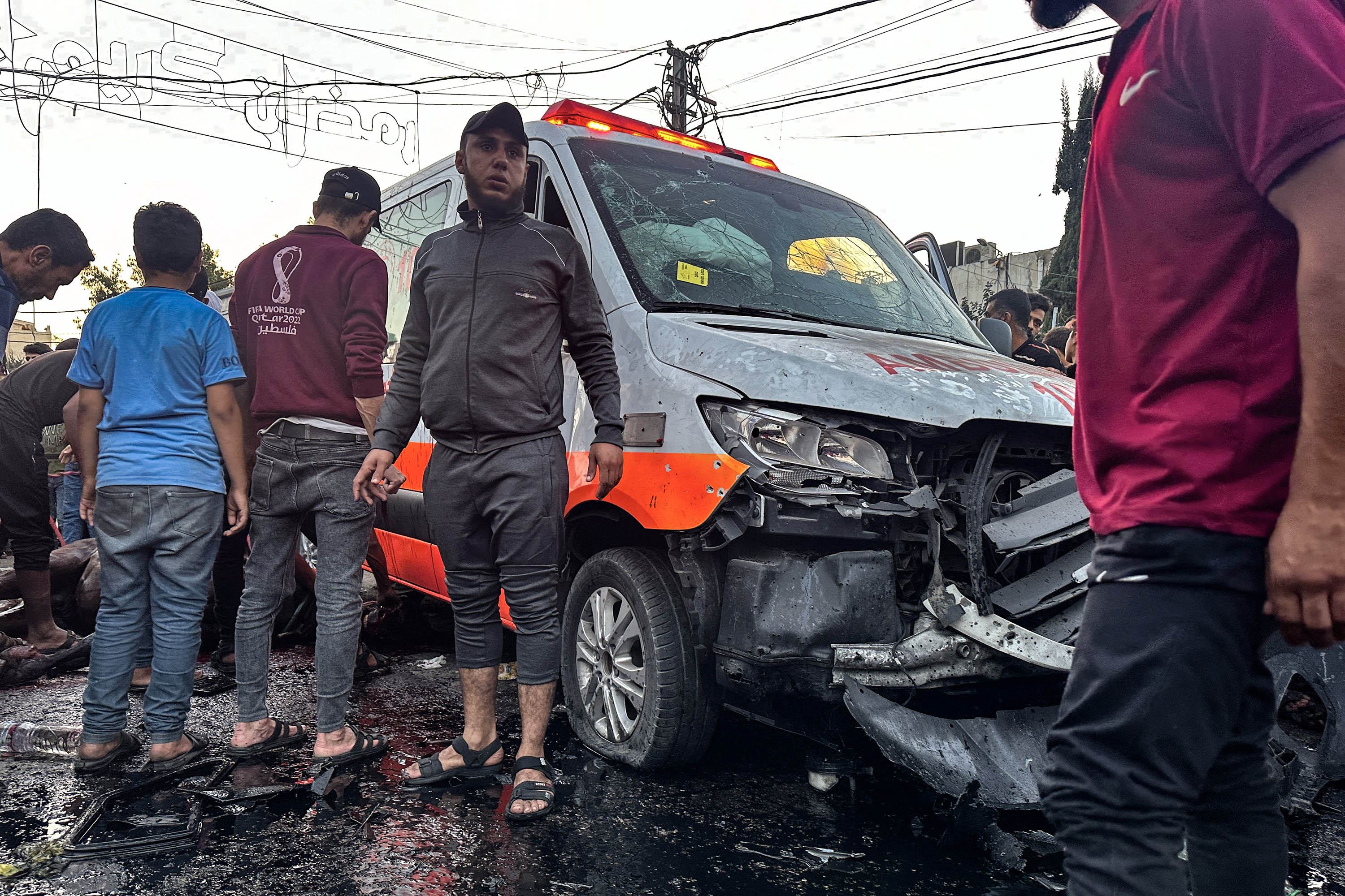 Orang-orang berkumpul di sekitar ambulans yang rusak akibat serangan Israel yang dilaporkan di depan rumah sakit Al-Shifa di Kota Gaza pada 3 November 2023, ketika pertempuran antara Israel dan gerakan Hamas Palestina terus berlanjut. Menurut kepala layanan pers pemerintah Hamas, serangan tersebut menargetkan