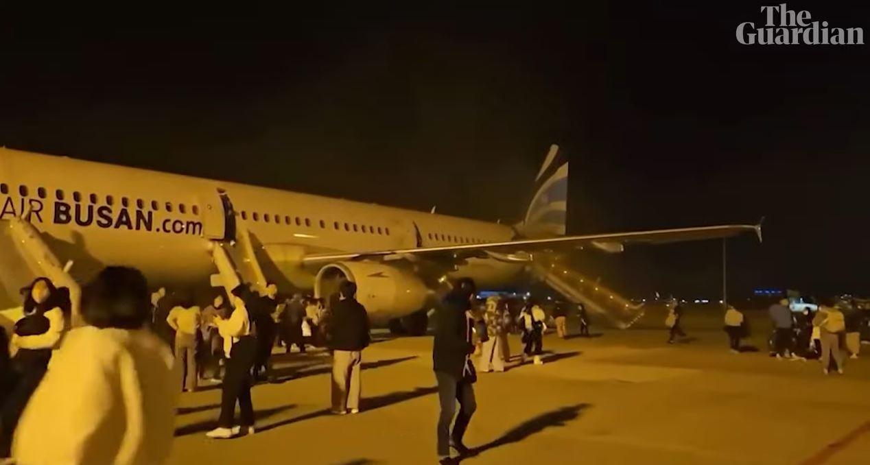 AIR BUSAN TERBAKAR - Tangkapan layar YouTube Guardian News yang diambil pada 29 Januari 2025, menunjukkan penumpang menyelamatkan diri setelah pesawat Air Busan terbakar di Bandara Internasional Gimhae, Korea Selatan pada 28 Januari 2025. Sumber kebakaran diduga berasal dari bagasi penumpang.