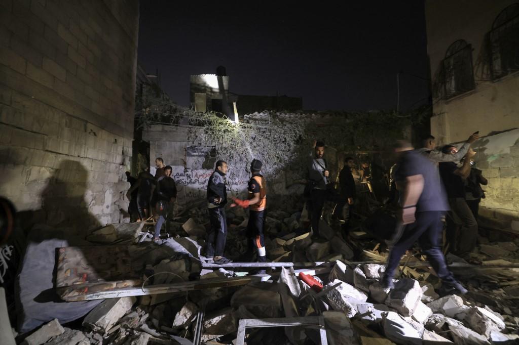 Personel darurat Palestina dan warga memeriksa puing-puing sebuah bangunan untuk para penyintas menyusul serangan Israel di Khan Yunis di Jalur Gaza selatan pada 15 November 2023, di tengah pertempuran yang sedang berlangsung antara Israel dan kelompok Palestina Hamas.