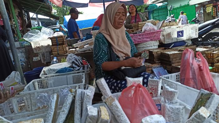 SURATINI BERJUALAN-   Lapak Suratini di Pasar Harjodaksino Solo, ia berjualan di bawah payung besar yang digunakan untuk dua pedagang.