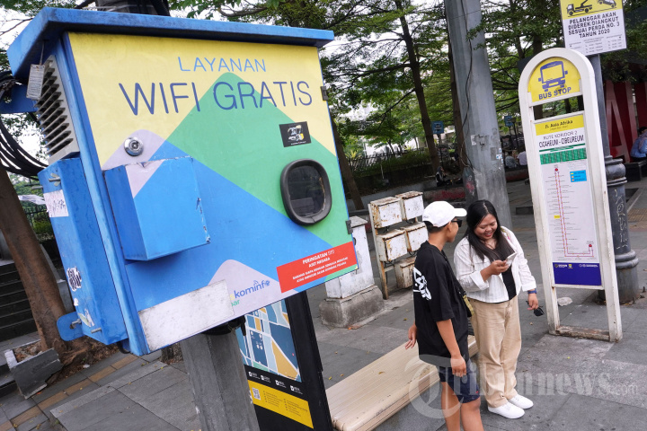 Warga Kecamatan Kepung sedang menggunakan layanan wifi gratis di pos kamling