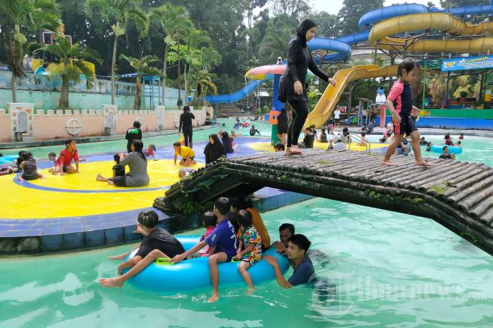 Pengunjung bermain di salah satu kolam renang saat berwisata di Karang Setra Waterland, Kota Bandung, Jawa Barat.