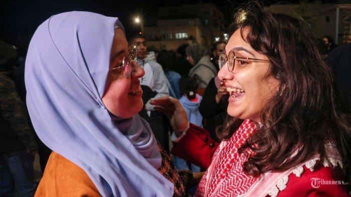 Raghad Fan (kanan) seorang tahanan Palestina yang ditahan di penjara Israel disambut oleh keluarganya saat dia dibebaskan berdasarkan kesepakatan gencatan senjata antara Israel dan Hamas dengan imbalan sandera yang ditahan di Gaza, di Baytunia di Tepi Barat yang diduduki pada 24 November 2023. Setelah 48 hari baku tembak dan pemboman yang merenggut ribuan nyawa, sandera pertama yang dibebaskan berdasarkan kesepakatan gencatan senjata antara Israel dan Hamas diserahkan pada 24 November, kata kedua belah pihak, hampir tujuh minggu setelah mereka ditangkap.