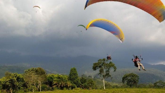 Wisatawan menikmati olahraga paralayang di Kemuning.