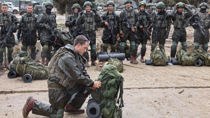 Tentara Israel bersiap untuk pergi ke Jalur Gaza, dekat daerah perbatasan di Israel selatan pada 13 Desember 2023 di tengah pertempuran yang sedang berlangsung dengan Pejuang Hamas Palestina. Israel menghadapi tekanan internasional yang meningkat pada 13 Desember atas perangnya di Gaza, dan bahkan pendukung utamanya, Amerika Serikat, mengkritik pemboman “tanpa pandang bulu” tersebut.