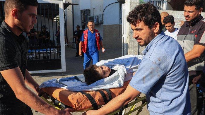 Petugas medis mengangkut seorang pemuda yang terluka dalam serangan udara Israel di daerah Beit al-Jazzar, ke rumah sakit al-Najjar di kota Rafah di Jalur Gaza selatan, pada 18 Oktober 2023, di tengah pertempuran yang sedang berlangsung antara Israel dan kelompok Palestina Hamas. Presiden AS Joe Bidden mendarat di Tel Aviv pada 18 Oktober ketika kemarahan Timur Tengah berkobar setelah ratusan orang tewas dalam ledakan rumah sakit di Gaza yang dilanda perang, yang mana Israel dan Palestina langsung saling menyalahkan.