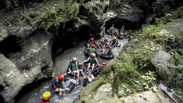 Menikmati tubing dengan pemandangan batuan karst.