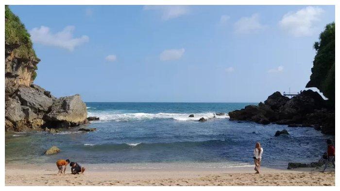 Pengunjung tampak bermain pasir di Pantai Torohudan