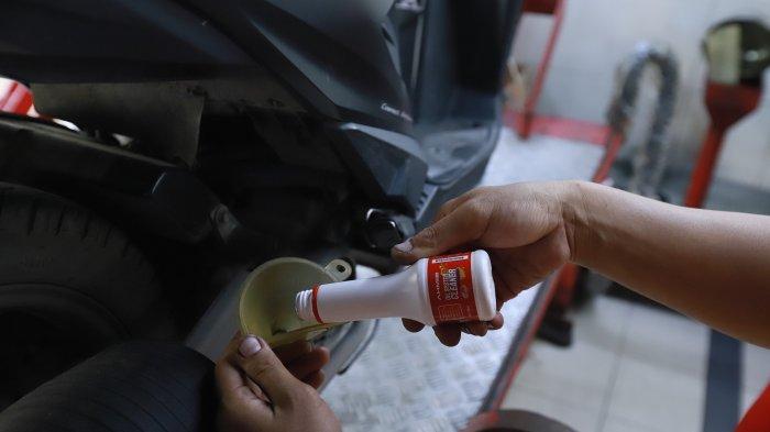 Salah satu teknisi AHASS sedang melakukan pembersihan jalur pelumas menggunakan Oil System Cleaner.