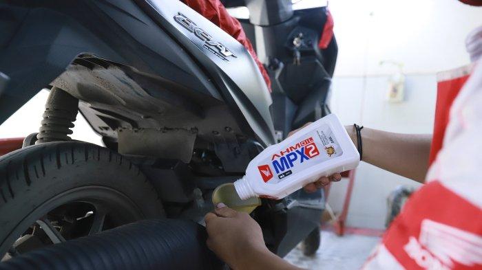 Teknisi AHASS melakukan penggantian pelumas sepeda motor Honda menggunakan AHM OIL MPX2 dengan ukuran 0,65L.