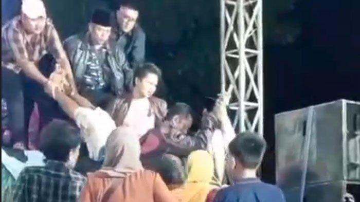 Warga menggotong tubuh seorang pria dari atas panggung