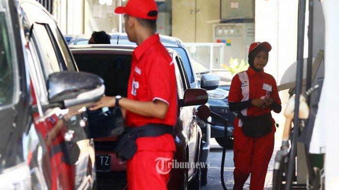 Petugas SPBU sedang mengisi BBM ke mobil