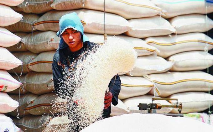BERAS - Kuli panggul sedang mengoplos beras di Pasar Induk Cipinang, Jakarta Timur. 